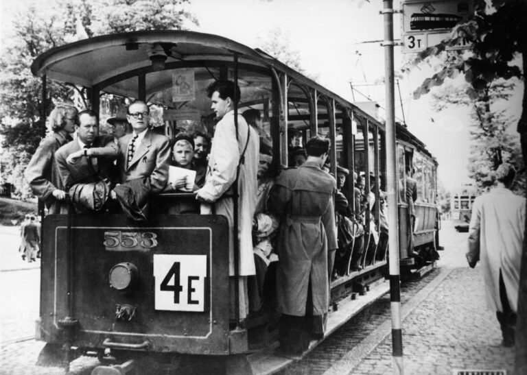 Fahrgäste auf dem Weg nach Munkkiniemi, Helsinki, in einer offenen Straßenbahn mit einem ausgehängten Ryhtiliike-Poster (1952). Bild: Stadtmuseum Helsinki